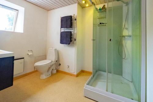 a bathroom with a toilet and a glass shower at Upstairs in Sæby