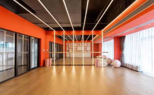 an empty room with orange walls and a dance floor at Keypai Hotel Free Shuttle Bus to Canton Fair in Guangzhou