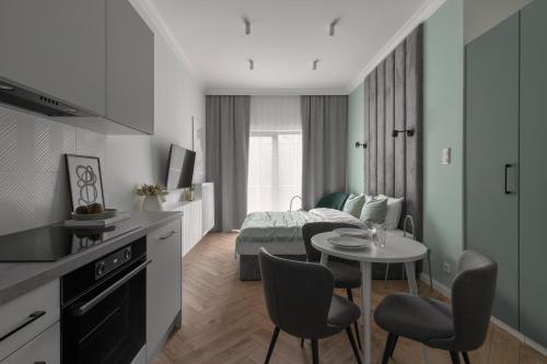 a room with a bed and a table and chairs at APARTIO ROOMS Gliwice in Gliwice