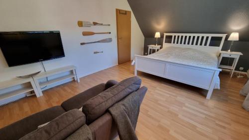 - un salon avec un canapé, un lit et une télévision dans l'établissement Ferienhaus-Kaethchen, à Nessmersiel
