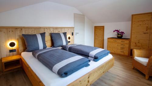 a bedroom with two beds with blue and white pillows at Alpinchalet in Pfronten