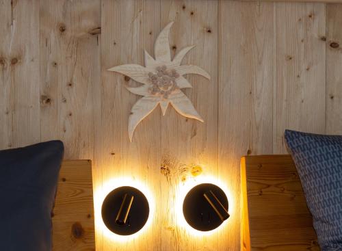 a table with two lights on a wooden wall at Alpinchalet in Pfronten