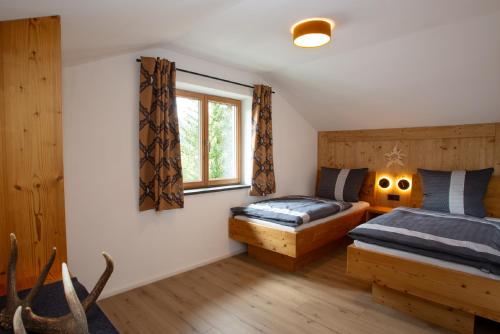 1 dormitorio con 2 camas y ventana en Alpinchalet, en Pfronten