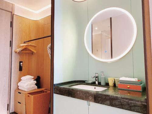 W łazience znajduje się umywalka i lustro. w obiekcie SSAW Boutique Hotel Zhijiang w mieście Hangzhou
