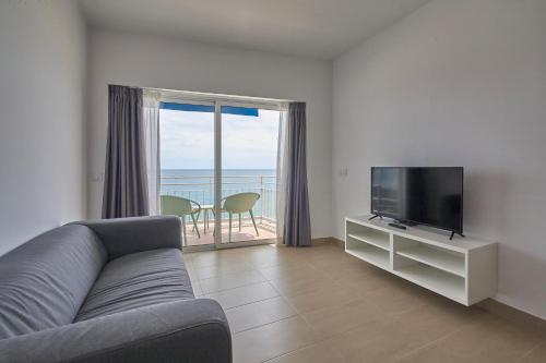 a living room with a couch and a flat screen tv at Aparthotel Xic in Platja  d'Aro