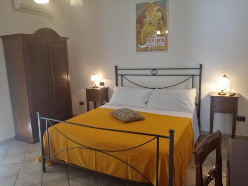 a bedroom with a bed with a yellow blanket on it at Hotel Pace in Pompei