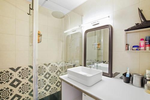 La salle de bains blanche est pourvue d'un lavabo et d'une douche. dans l'établissement Appartement Calme et Moderne avec vue mer 74, à Canet