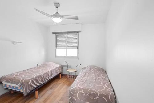 - une chambre avec un lit, un canapé et une fenêtre dans l'établissement Appartement Calme et Moderne avec vue mer 74, à Canet