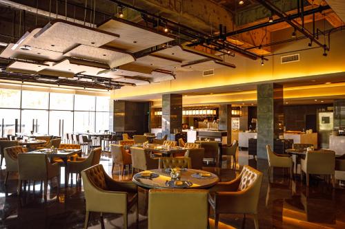 a restaurant with tables and chairs in a room at The Sifang Hotel Nanjing, Autograph Collection in Nanjing