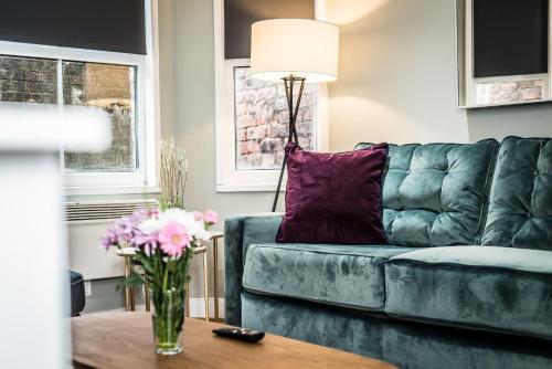 a living room with a blue couch with a purple pillow at Host & Stay - The Georgian Quarters at Bedford in Liverpool