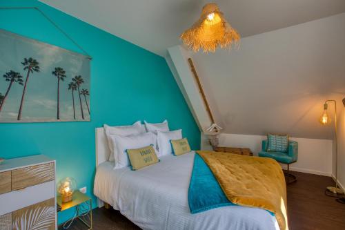 - une chambre avec un lit et un mur bleu dans l'établissement O'Myosotis, à Sarlat-la-Canéda