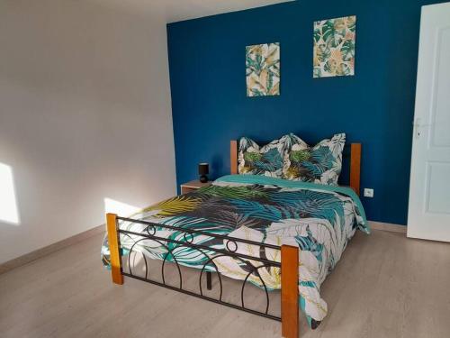 a bedroom with a bed with a blue wall at Maison de vacances Leu ti coin des ô in Saint-Leu