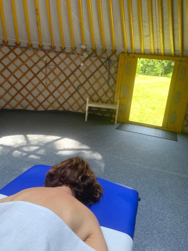 a woman laying on a blue chair in a yurt at Lélek-Tér in Siófok