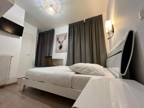 a small bedroom with a bed and a window at Hôtel Belle Fontainebleau in Fontainebleau