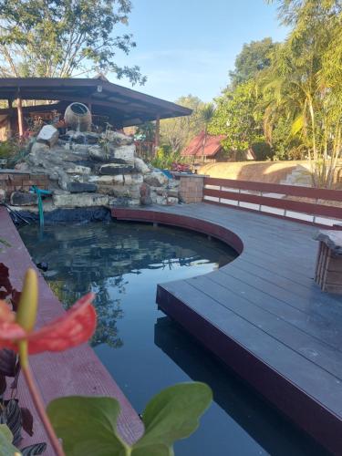 a swimming pool with a wooden deck and a bridge at Phulomnum Resort in Ban Thung Samo