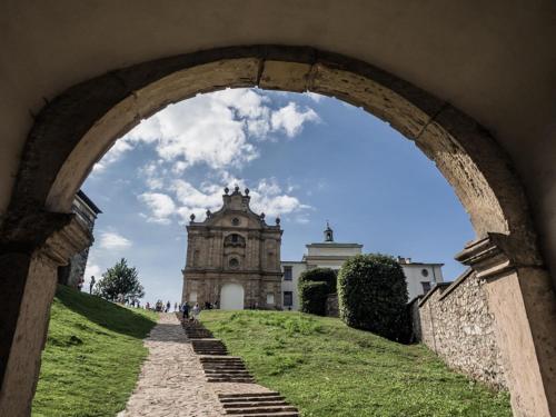 an archway leading to a building with a clock tower at Domek Przy Osadzie in Bieliny