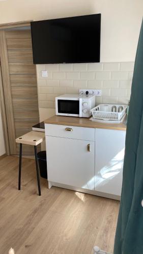 a kitchen with a microwave and a tv on a counter at Night & Flight Airport Apartman in Vecsés