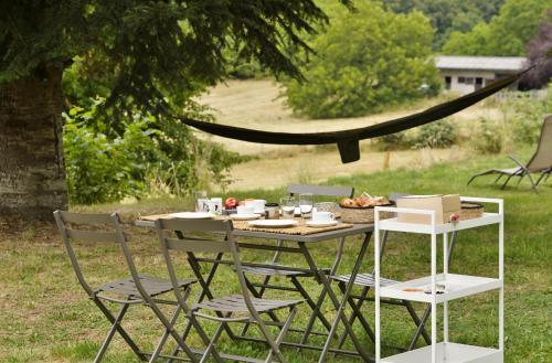 een tafel met stoelen en een bord eten erop bij Une pause en Corrèze in Sarroux