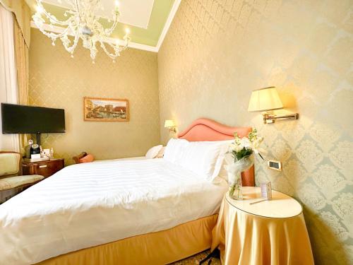 a bedroom with a bed and a table with a lamp at Hotel Colombina in Venice