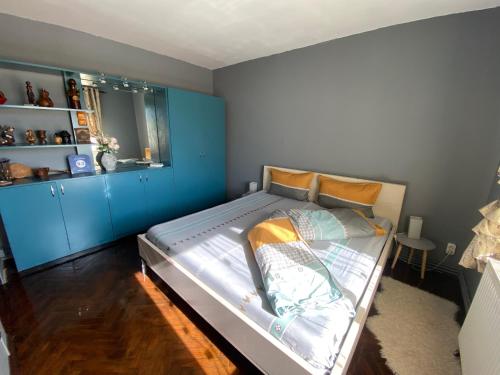 sypialnia z dużym łóżkiem z niebieskimi ścianami w obiekcie Comfort Home Apartment 2 w mieście Petroszany