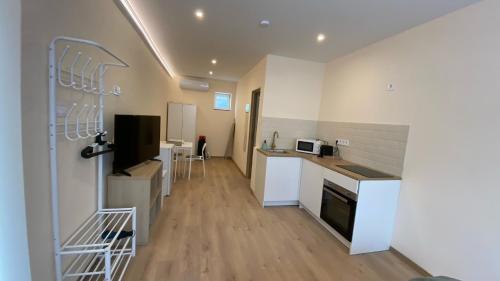 uma cozinha com armários brancos e uma bancada em Night & Flight Airport Apartman em Vecsés
