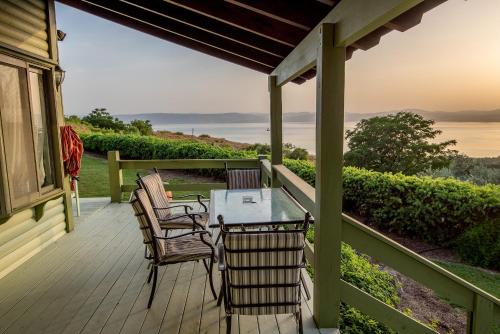 a table and chairs on a porch with a view of the ocean at Sea of Galilee Panoramic View in Moshav Ramot