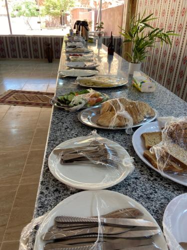 a long table with plates of food on it at Bilal luxury camp in Wadi Rum