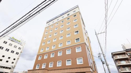 a tall building in the middle of two buildings at Toyoko Inn Nara Oji eki Minami guchi in Oji