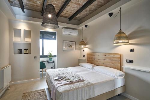 a bedroom with a bed and two pendant lights at AinB Eixample-Miro Apartments in Barcelona