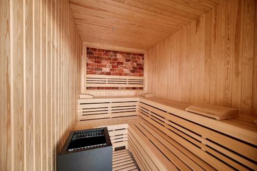 an empty wooden sauna with a brick wall at Beach Side Heaven Apartment in Infinity Beach Resort - parking in Mamaia