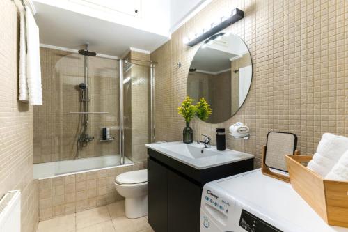 een badkamer met een wastafel, een toilet en een spiegel bij Nana's House in Athene