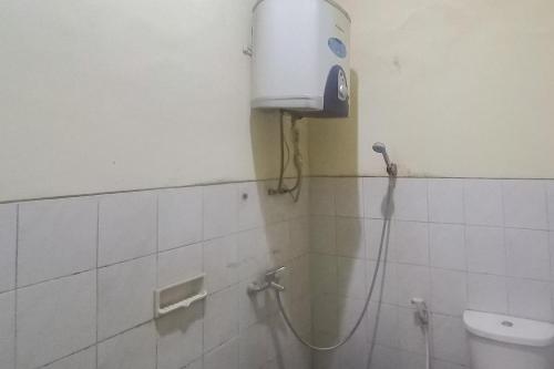 een douche in een badkamer met een waterdispenser aan de muur bij Hotel Malang near Alun Alun Malang RedPartner in Malang