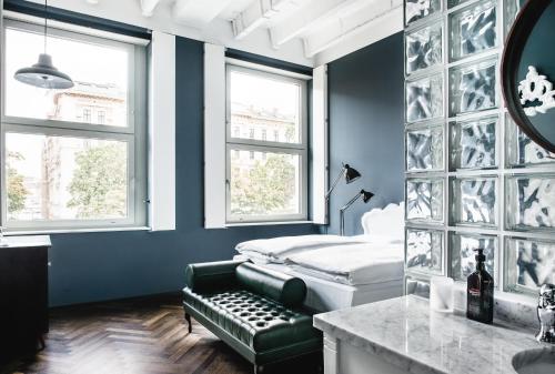 1 dormitorio con cama, sofá y ventanas en Grand Ferdinand Vienna – Your Hotel In The City Center en Viena