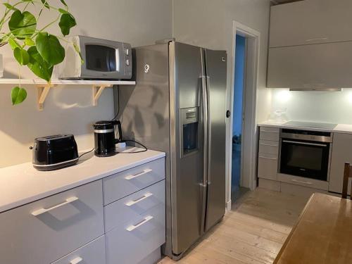 una cucina con frigorifero in acciaio inox e forno a microonde di Iso kaupunkikoti Vanhan Rauman lähellä a Rauma