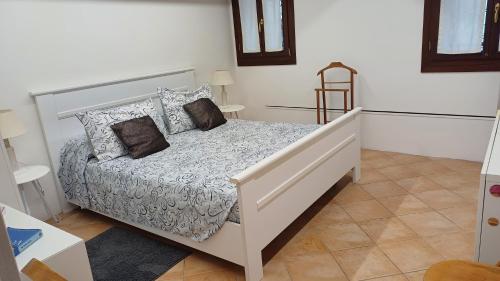 ein Schlafzimmer mit einem weißen Bett mit Kissen in der Unterkunft Fiore della Laguna in Venedig