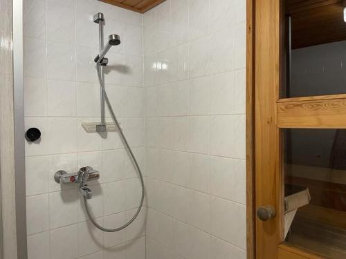 a shower with a shower head in a bathroom at Kielaslinna above the Arctic Circle in Suomutunturi