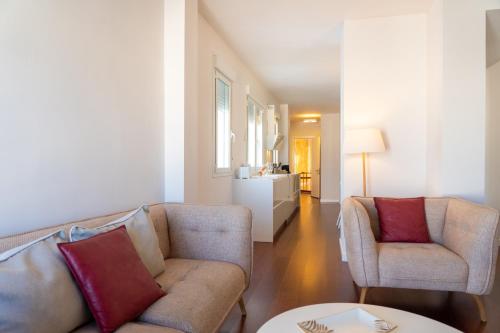 a living room with two couches and a table at Plaza Mina Suites - Adults Recommended by Luxury Suites Cadiz in Cádiz