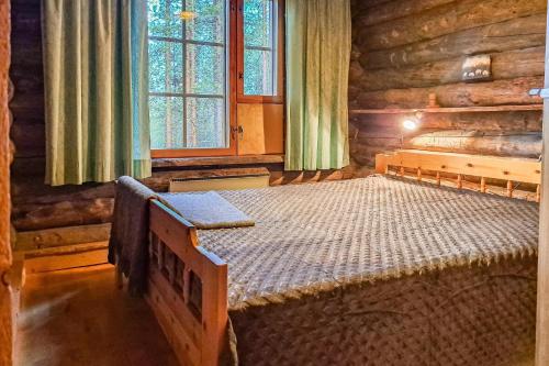 a bedroom with two beds in a log cabin at Kielaslinna above the Arctic Circle in Suomutunturi
