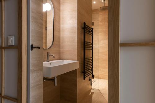 a bathroom with a white sink and a mirror at Gozo Harbour Views, Mgarr Heights in Mġarr