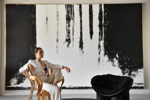 a woman sitting in a chair in front of a window at Gozo Harbour Views, Mgarr Heights in Mġarr