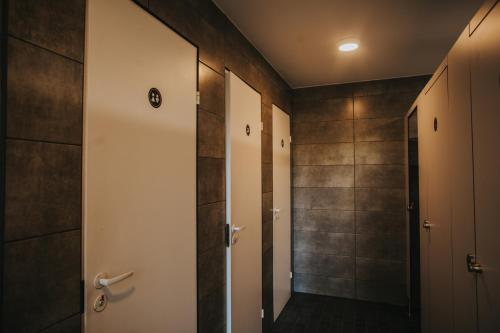 a bathroom with a walk in shower next to a door at BB camping in Liepāja