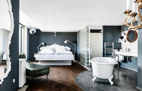1 dormitorio con cama blanca y bañera en Grand Ferdinand Vienna – Your Hotel In The City Center en Viena