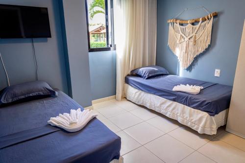 two beds in a room with blue walls at Refúgio na Praia do Forte in Praia do Forte