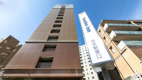 a tall building with a sign in front of it at Toyoko Inn Shiki eki Higashi guchi in Shiki