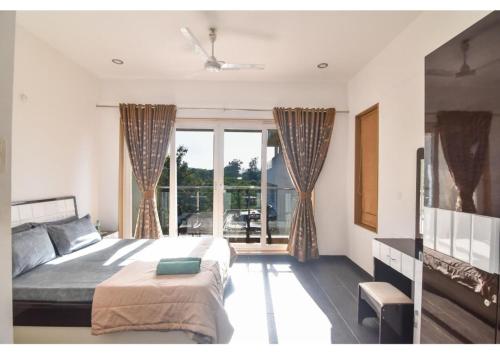 a bedroom with a bed and a large window at Nestle Villa 5BHK in Lonavala