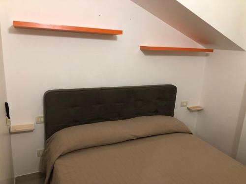 łóżko w pokoju z półkami na ścianie w obiekcie Mansarda Mentana due w mieście Vittoria
