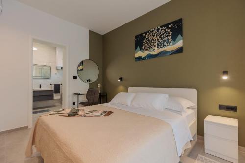 een slaapkamer met een wit bed en een spiegel bij Villa Mara in Vrsi