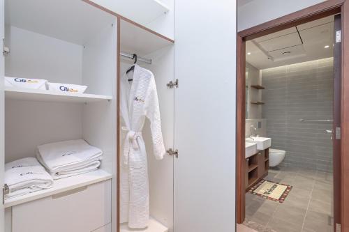 a white bathroom with a shower and a sink at CitiHome-2BR world trade center with full Park and Dubai Frame view in Dubai