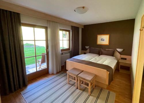 a bedroom with a bed and a large window at Aria d' Prè in Badia