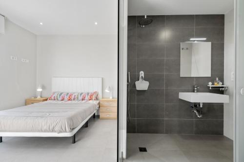 - une chambre avec un lit, un lavabo et un miroir dans l'établissement Casa Sandra, à San Pedro del Pinatar